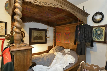 Schlafstube mit Himmelbett im Grönegau-Museum Melle Ein detailliertes Himmelbett aus Holz mit aufwendigen Schnitzereien und traditioneller Dekoration.
