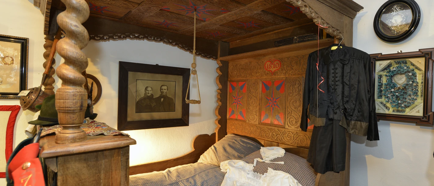 Schlafstube mit Himmelbett im Grönegau-Museum Melle Ein detailliertes Himmelbett aus Holz mit aufwendigen Schnitzereien und traditioneller Dekoration.