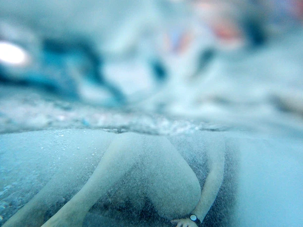 Sprudelliegen im Solebecken Underwater shot of a person in a pool, water surface slightly blurred.