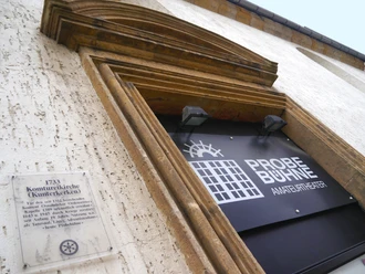 Eingang zur Probebühne Osnabrück, ein Amateur-Theater, mit historischem Kirchenportal und Infotafel.