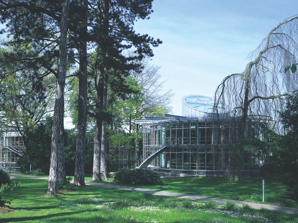 Die Deutsche Bundesstiftung Umwelt in Osnabrück Moderne Glasarchitektur der Deutschen Bundesstiftung Umwelt, umgeben von hohen Bäumen und Grünflächen.