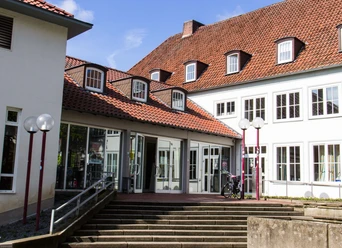 Das Haus der Jugend Osnabrück Eingang zum Haus der Jugend in Osnabrück mit rotem Ziegeldach und großen Fenstern im Tageslicht.