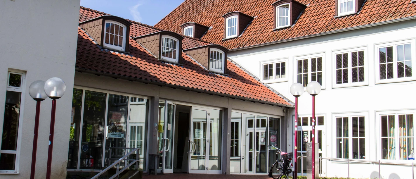 Das Haus der Jugend Osnabrück Eingang zum Haus der Jugend in Osnabrück mit rotem Ziegeldach und großen Fenstern im Tageslicht.