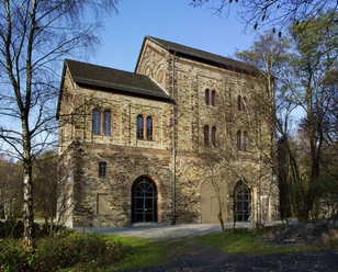 Das Museum Industriekultur in Osnabrück Brick building of the Museum of Industrial Culture in Osnabrück with arches and windows, surrounded by trees.