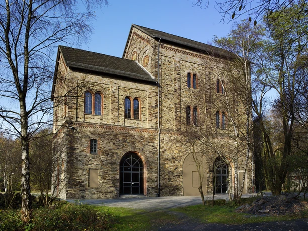 Das Museum Industriekultur in Osnabrück Backsteingebäude des Museums Industriekultur in Osnabrück mit Bögen und Fenstern, umgeben von Bäumen.