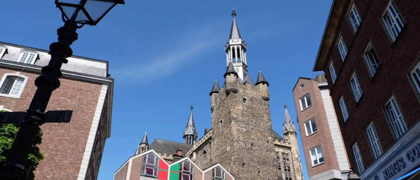 Der viereckige Granusturm steht in der Mitte historischer Gebäude vor blauem Himmel.