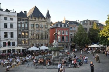 Belebter Marktplatz mit historischen Gebäuden und dem Karlsbrunnen im Zentrum.