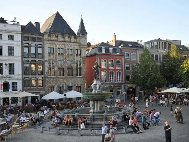 Marktplatz Belebter Marktplatz mit historischen Gebäuden und dem Karlsbrunnen im Zentrum.