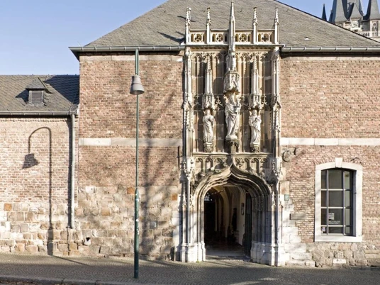 Die gotische Fassade der Domschatzkammer mit detaillierten Skulpturen und spitzbogigem Eingang aus hellem Stein.