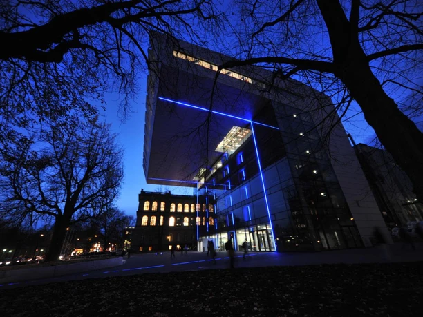 SuperC Modernes Gebäude mit futuristischer Architektur ist bei Nacht in blauen LED-Lichtern erleuchtet.