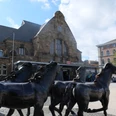 Vor dem historischen Gebäude des Aachener Hauptbahnhofes stehen vier Pferde aus Bronze auf dem Vorplatz.