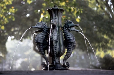 Ein symmetrischer Brunnen mit Seepferdchen aus Bronze, die Wasser speien.