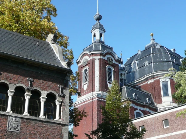 Barocke Kirche mit rotem Ziegelstein, weißen Verzierungen und einer markanten Kuppel.