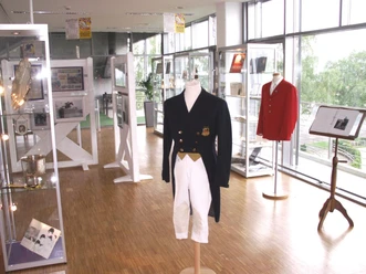 Ausstellungsraum mit Vitrinen und Mannequins mit Reiterkleidung.
