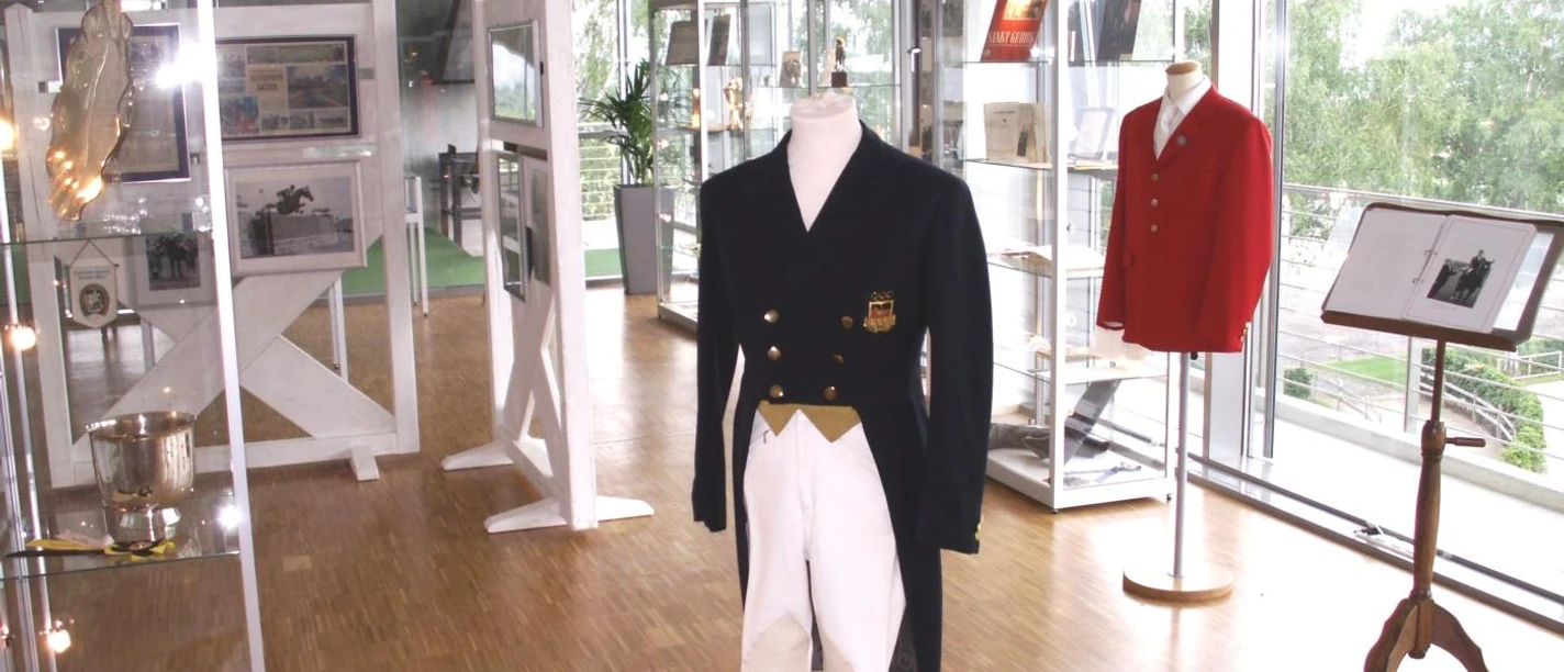 Ausstellungsraum mit Vitrinen und Mannequins mit Reiterkleidung.