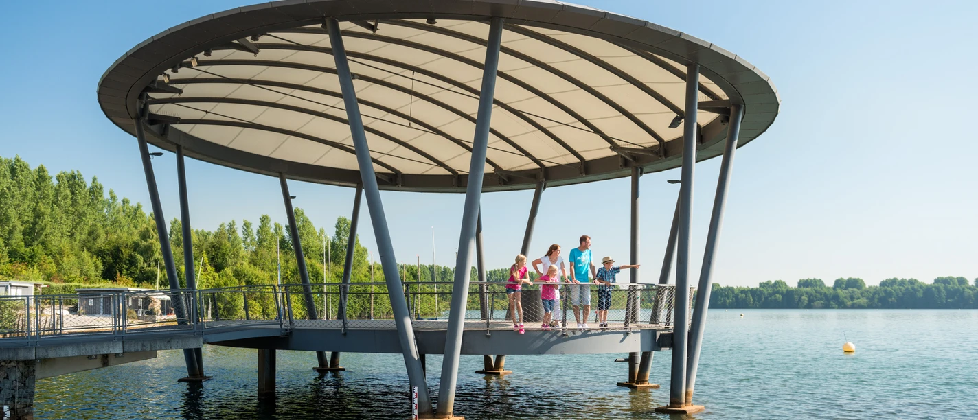Blausteinsee Eine Familie genießt den sonnigen Tag auf einem modernen Steg über dem Blausteinsee.