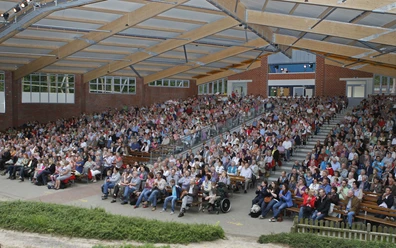 Waldbühne Ahmsen Großes überdachtes Freilichttheater mit dicht besetzten Rängen und barrierefreien Sitzplätzen.