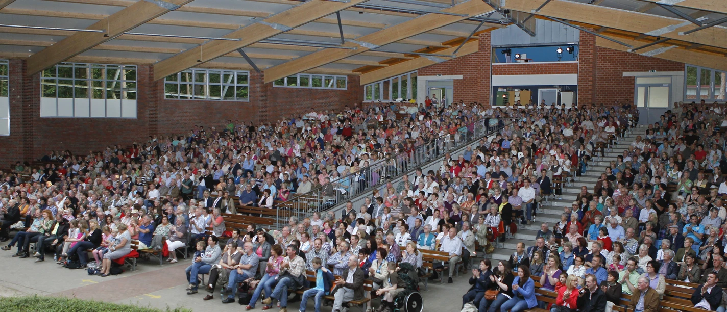 Waldbühne Ahmsen Großes überdachtes Freilichttheater mit dicht besetzten Rängen und barrierefreien Sitzplätzen.