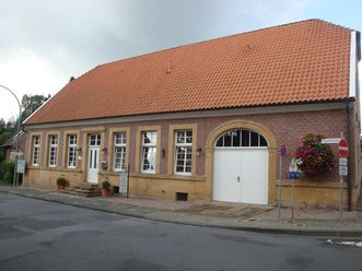 Alte Amtsvogtei Backsteinbau mit rotem Ziegeldach, weißen Fenstern und großem Tor in der Papenstraße Emsbüren.