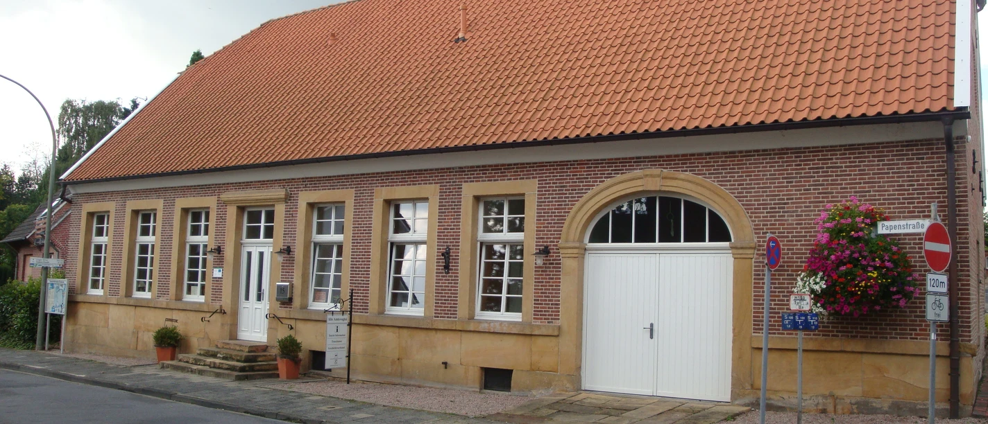Alte Amtsvogtei Backsteinbau mit rotem Ziegeldach, weißen Fenstern und großem Tor in der Papenstraße Emsbüren.