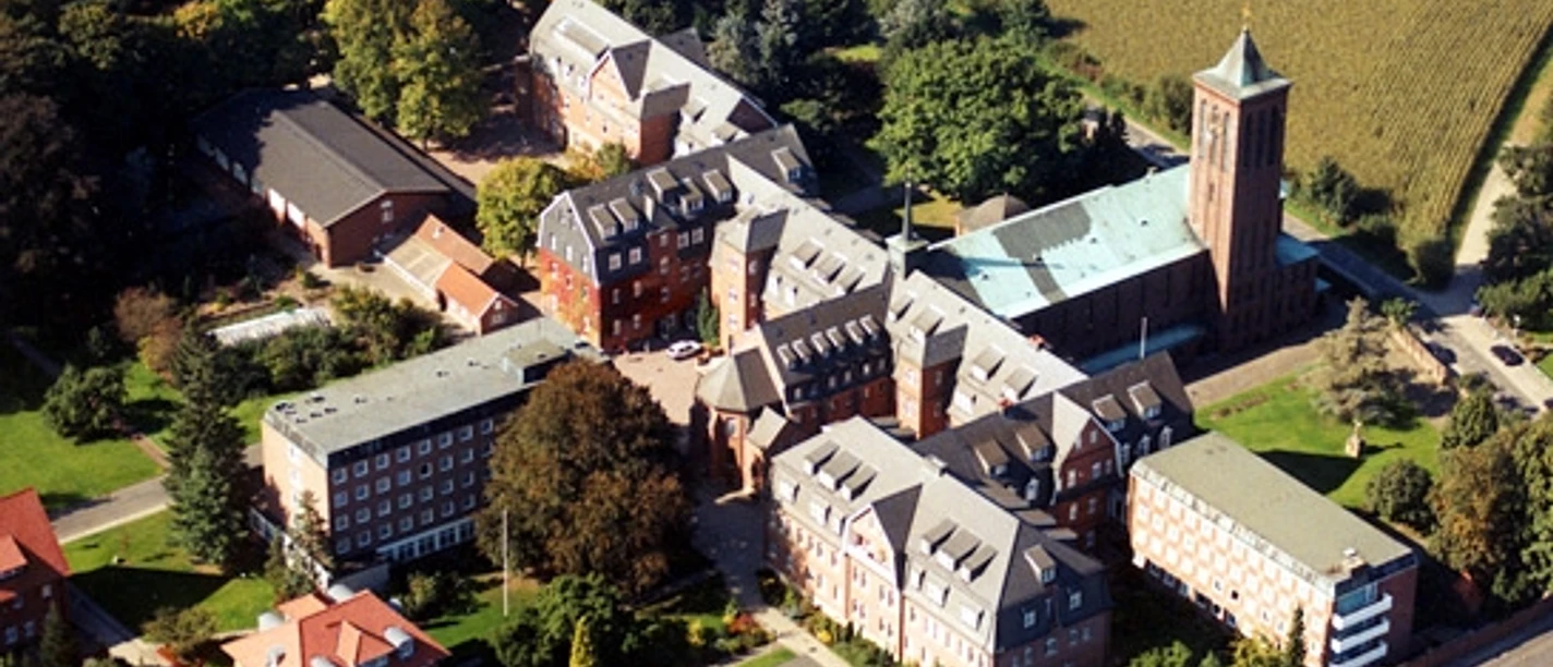 Franziskanerinnenkloster in Thuine Luftaufnahme des Franziskanerinnenklosters Thuine mit roten Backsteingebäuden und hohem Kirchturm