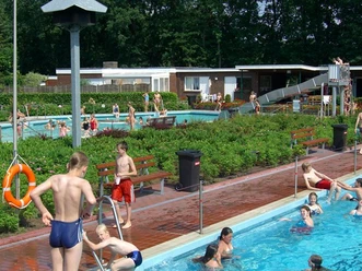 Freibad Haselünne Kinder und Erwachsene baden im Freibad Haselünne mit Becken, Rutsche und grüner Gartenanlage.