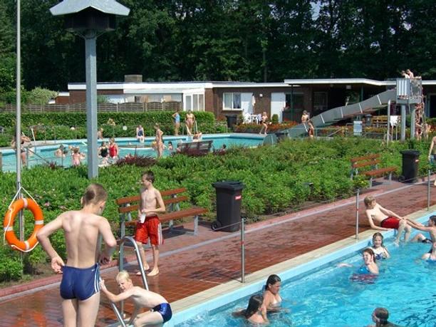 Freibad Haselünne Kinder und Erwachsene baden im Freibad Haselünne mit Becken, Rutsche und grüner Gartenanlage.