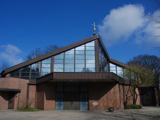 Heede Wallfahrtskirche Moderne Backsteinkirche mit markanter Dachform, großen Glasflächen und Kreuz auf dem Giebel.