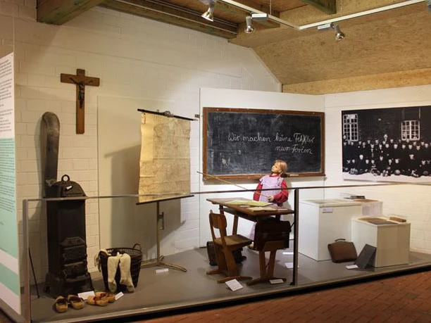 Heimatmuseum Esterwegen Ausstellungsraum mit historischem Klassenzimmer, alter Schulbank, Tafel, Schulmaterialien und Puppe