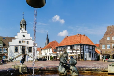 historisches-rathaus-und-alte-posthalterei-foto-helmut-kramer-16041443 Historisches Rathaus mit Uhrturm, Fachwerkhaus und Brunnenfiguren auf dem Marktplatz in Lingen.