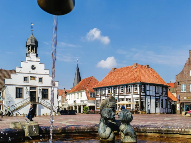 historisches-rathaus-und-alte-posthalterei-foto-helmut-kramer-16041443 Historisches Rathaus mit Uhrturm, Fachwerkhaus und Brunnenfiguren auf dem Marktplatz in Lingen.