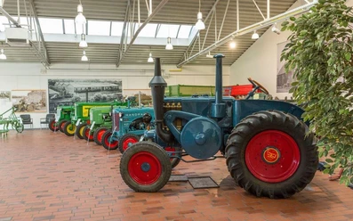 Krone Museum Reihe historischer Traktoren in einer hellen Museumshalle mit Ziegelboden und Landtechnik-Ausstellung.