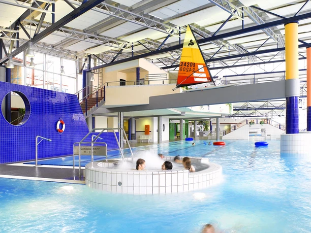 Linus Lingen Wasserwelten Innenansicht eines modernen Hallenbads mit blau gefliesten Wänden, Whirlpool und großem Becken.