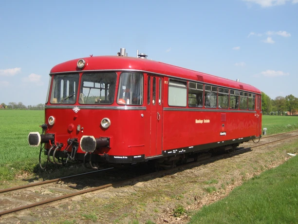 Museumseisenbahn Hümmlinger Kreisbahn Roter Triebwagen der Museumseisenbahn Hümmlinger Kreisbahn auf Gleisen durch grüne Wiesen fahrend