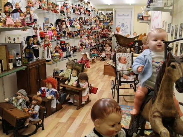 Uli's Puppenstube im Bürgerhaus Alte Schule Raum mit zahlreichen historischen Puppen, Puppenwagen und Spielzeug aus verschiedenen Epochen.