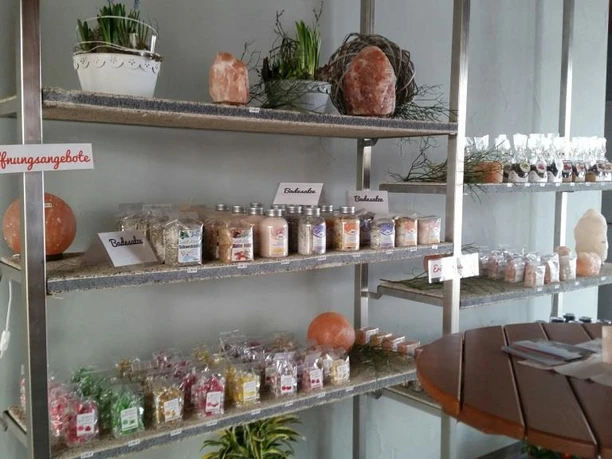 Salz in vielen Variationen Regal mit verschiedenen Salzprodukten, Badezusätzen und Salzlampen in einem Wellnessraum.