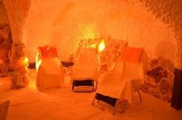 Salzgrotte RELAXX Beleuchtete Salzgrotte mit Liegestühlen aus Stoff und salzverkrusteten Wänden in warmem Licht