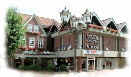 Schröder Mode Backsteinbau mit großen Schaufenstern und Schriftzug Mode Schröder am Marktplatz in Haselünne.