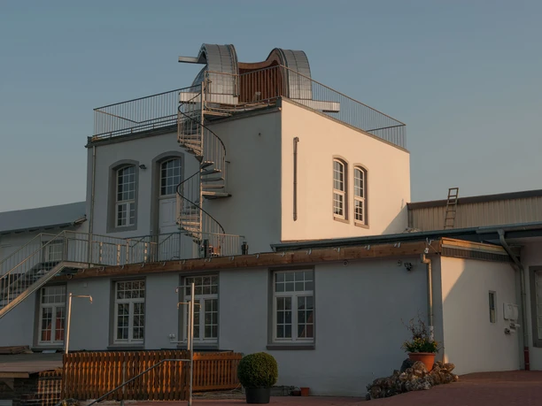 Sternwarte Papenburg Zweigeschossiges Gebäude mit weißer Fassade, Dachkuppel und Wendeltreppe der Sternwarte Papenburg.