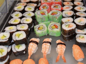 Sushi bei China Town Verschiedene Sushi-Sorten mit Noriblatt, Avocado, Lachs und Garnelen auf Kunststoffplatte angerichtet.