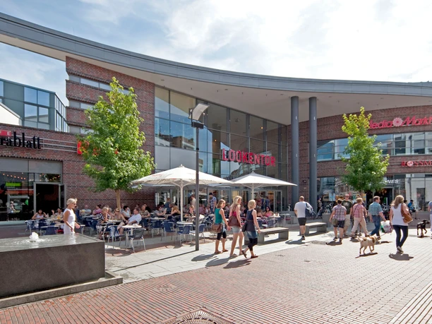 Lookentor Lingen Einkaufszentrum Lookentor in Lingen mit Glasfassade, Straßencafé und Passanten bei Sonnenschein