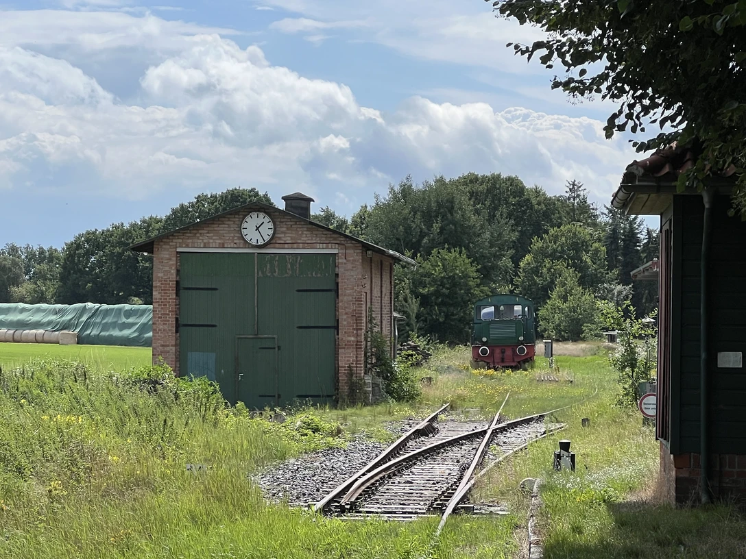 Verden-Stemmen Ein alter Güterschuppen mit grünen Toren und Uhr, daneben ein Schienenweg mit einer historischen Lokomotive.An old goods shed with green gates and clock, next to it a rail track with a historic locomotive.En gammel godsbanegård med grønne porte og ur, ved siden af et jernbanespor med et historisk lokomotiv.Een oude goederenloods met groene hekken en klok, ernaast een treinspoor met een historische locomotief.