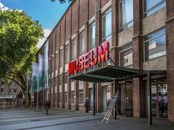 Museum für Angewandte Kunst Köln Das Bild zeigt die Fassade des Museums für Angewandte Kunst Köln mit auffälliger roter Neonschrift.The picture shows the façade of the Museum of Applied Arts Cologne with striking red neon lettering.