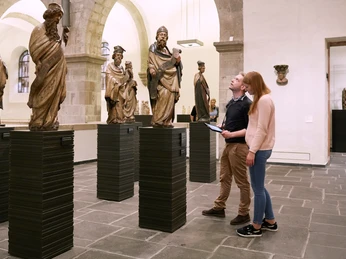 Museum Schnütgen Cologne Zwei Personen betrachten mittelalterliche Skulpturen in einem lichtdurchfluteten Raum des Museums.Two people look at medieval sculptures in a light-flooded room of the museum.