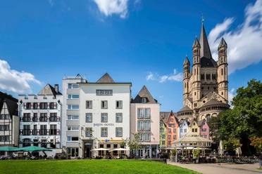 Cologne old town Rhine bank Cologne's old town on the banks of the Rhine features picturesque colorful houses and is dominated by the imposing Gross St. Martin Church, set against a bright blue sky.