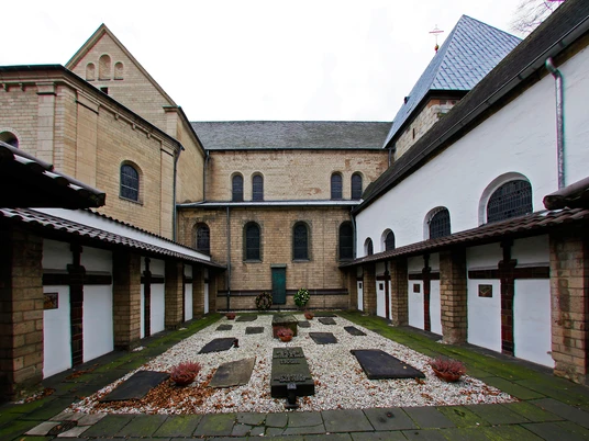 Sankt Georg Innenhof der romanischen Kirche St. Georg in Köln, umgeben von historischen Gebäudestrukturen.Inner courtyard of the Romanesque church of St. George in Cologne, surrounded by historic building structures.