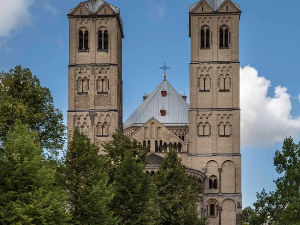 Sankt Gereon Romanische Kirche Sankt Gereon in Köln mit zwei markanten Türmen, umgeben von grünen Bäumen.