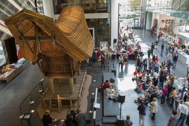 Rautenstrauch-Joest-Museum Das Bild zeigt das belebte Foyer des Rautenstrauch-Joest-Museums während eines Themen-Tages. Im Mittelpunkt steht ein traditionelles indiges Hausmodell aus Holz.