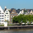 Pegel Köln Reihen schiefer Fachwerkhäuser mit spitzen Dächern säumen das Rheinufer unter strahlend blauem Himmel.Rows of crooked half-timbered houses with pointed roofs line the banks of the Rhine under a bright blue sky.