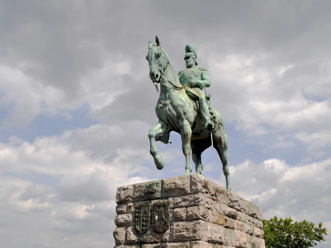Equestrian statue of Emperor Frederick III. Reiterstandbild von Kaiser Friedrich III. in Köln: Ein bronzenes Reiterdenkmal auf einem steinernen Sockel unter dramatischem Himmel.Equestrian statue of Emperor Frederick III in Cologne: a bronze equestrian monument on a stone pedestal under a dramatic sky.